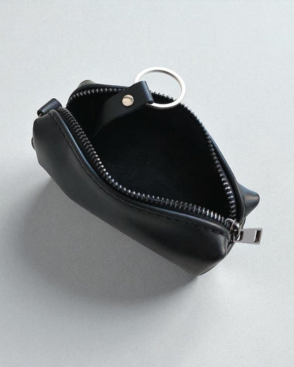 A small black leather zippered pouch with a silver metal key ring attachment, shown open on a light gray background.