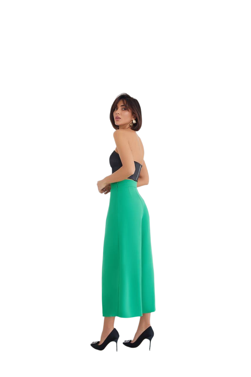 Woman wearing a strapless top and green skirt on a white background