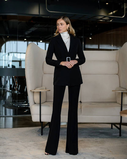 Woman in a black suit standing in a modern interior setting