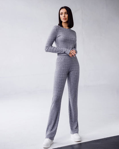 Woman wearing a gray knit outfit on a white background