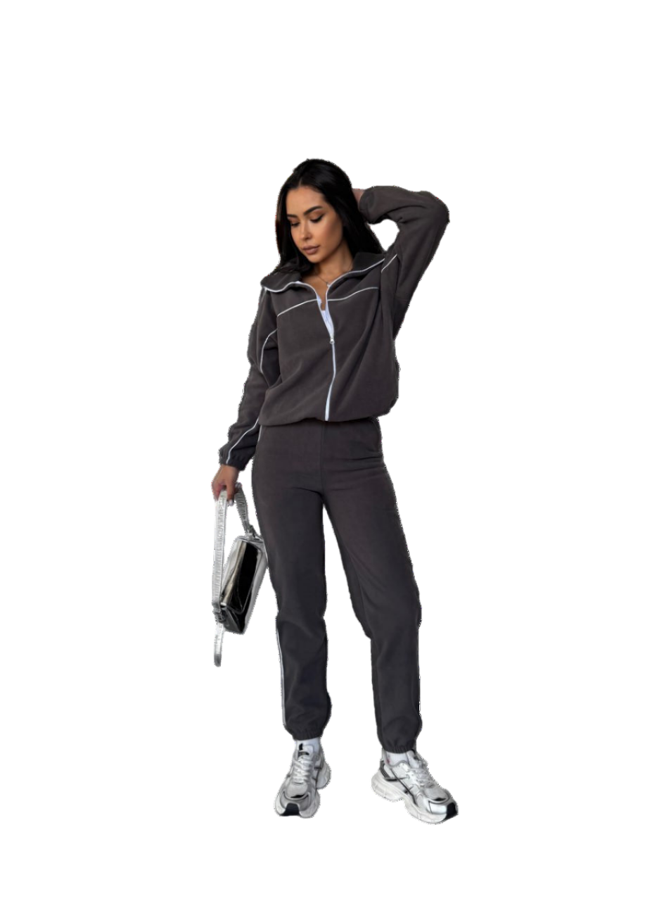 Woman in a dark tracksuit holding a disco ball on a white background