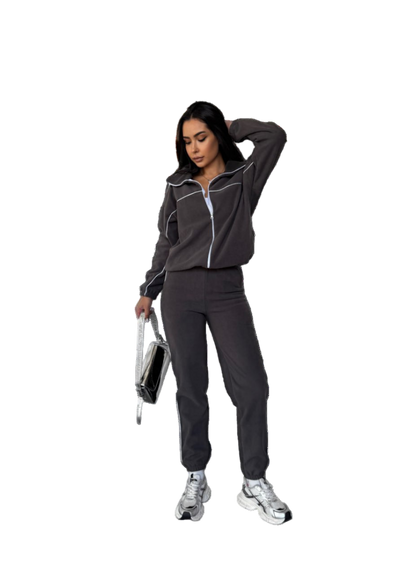 Woman in a dark tracksuit holding a disco ball on a white background