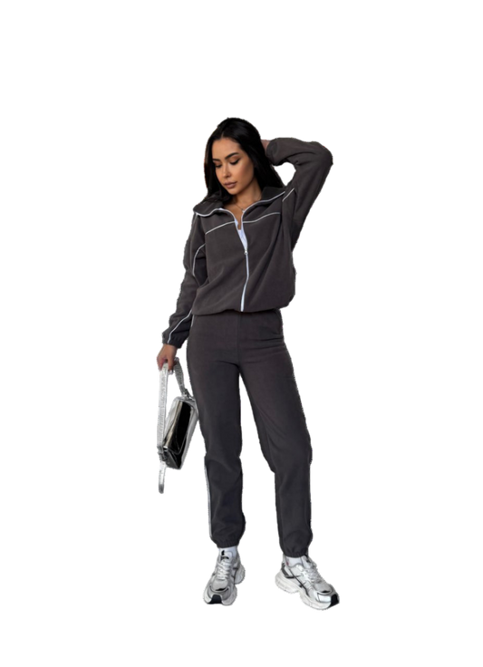 Woman in a dark tracksuit holding a disco ball on a white background