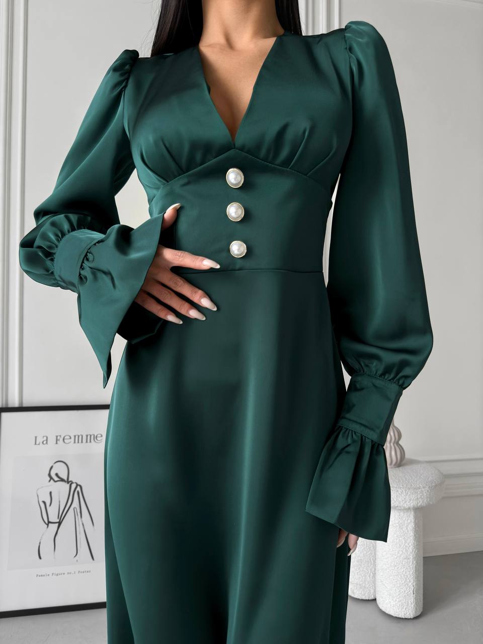 Green dress with puff sleeves and button details on a neutral background