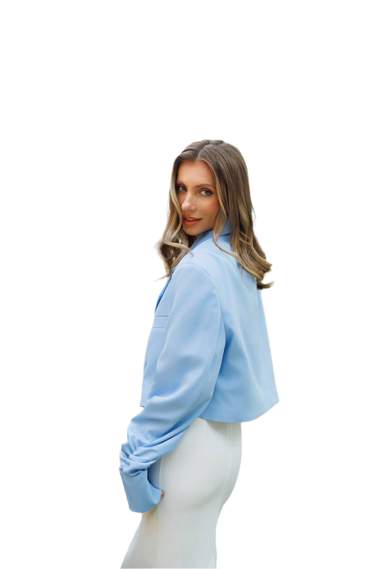 Woman wearing a light blue blouse and white pants on a white background