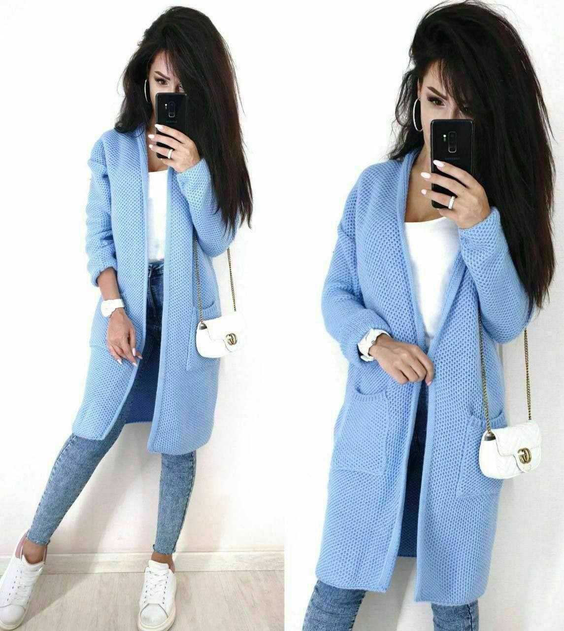 Woman wearing a light blue cardigan in front of a white background