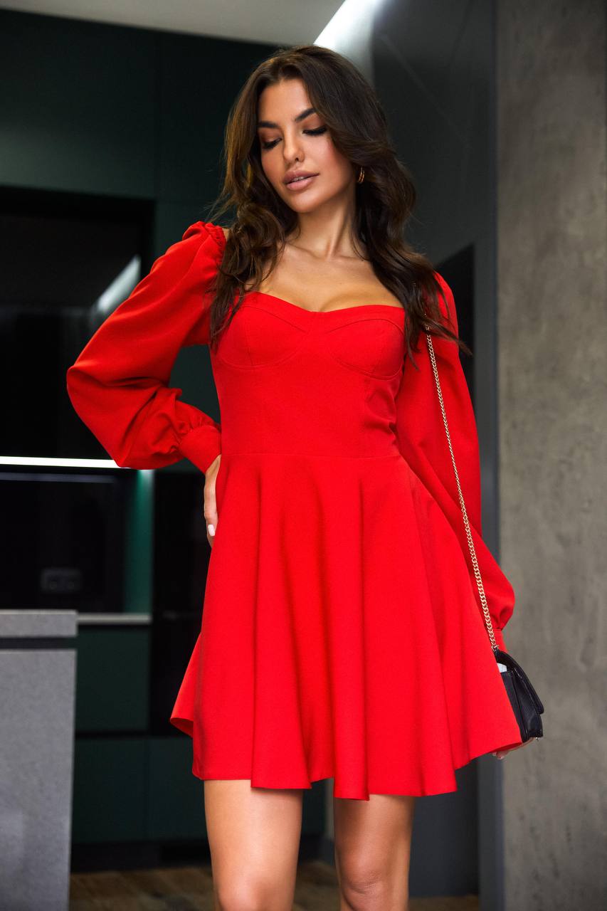Woman wearing a red dress with long sleeves in an indoor setting