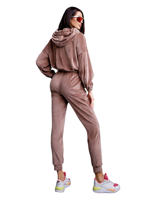 Woman wearing a brown tracksuit with colorful sneakers on a white background