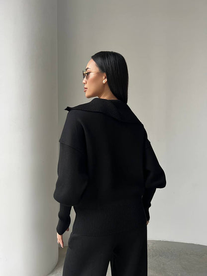 Person wearing a black outfit against a plain background