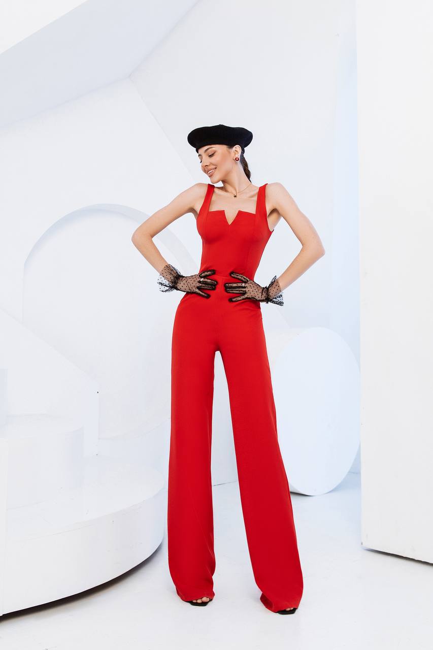 Person wearing a red jumpsuit with a black hat and gloves on a white background