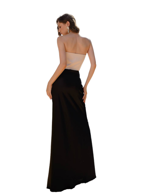 Woman wearing a strapless beige top and black floor-length skirt on a white background