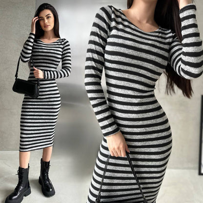 Woman wearing a black and white striped dress with a plain background