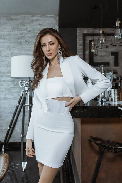 Woman in a white outfit posing in an indoor setting
