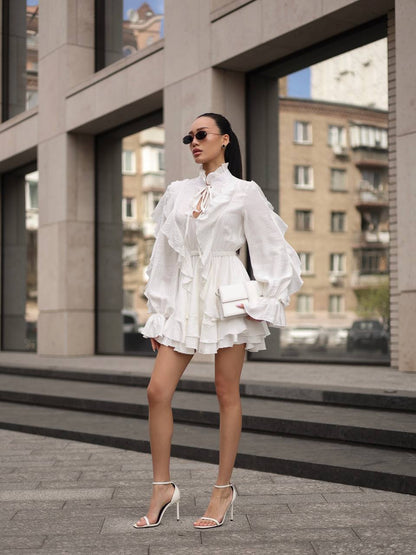 Woman in a white ruffled dress standing in an urban setting
