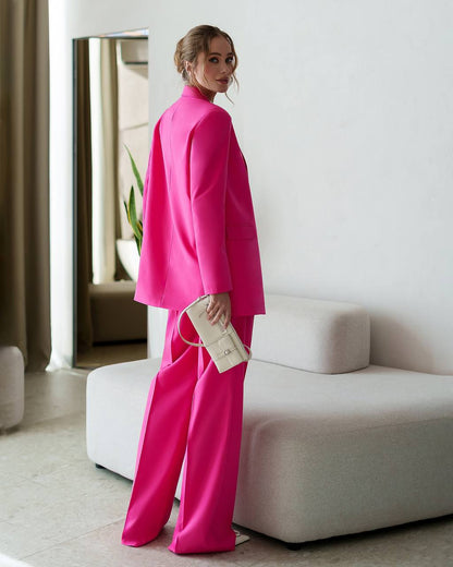 Woman in a bright pink outfit standing in a modern room.