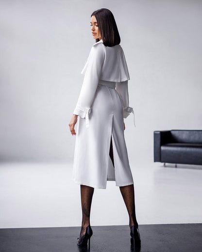 Woman wearing a white outfit with a jacket in a minimalistic setting