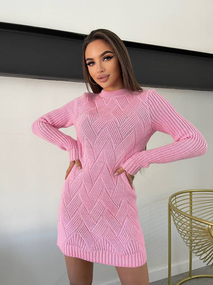 Woman wearing a pink knitted dress against a neutral background