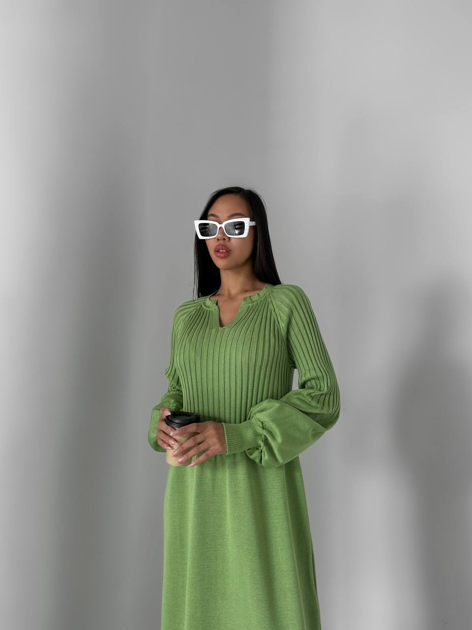 Woman wearing a green dress against a gray background