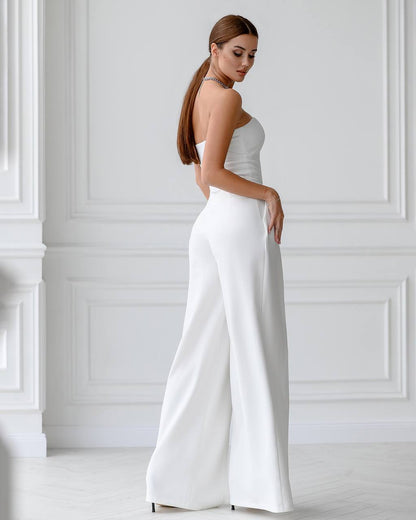 Woman wearing a white strapless jumpsuit in a minimalistic setting