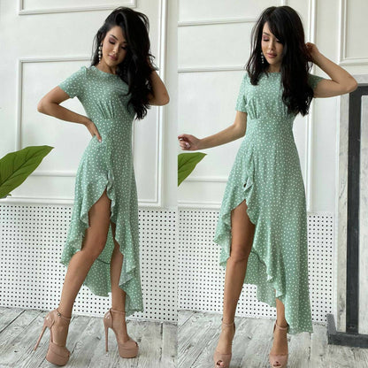 Woman wearing a light green dress with a slit, standing indoors.
