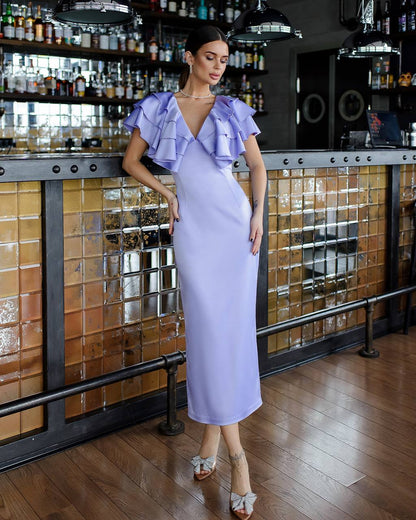 Woman in a lavender dress standing in a bar setting