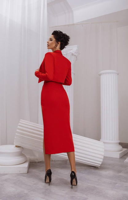 Woman in a red dress standing in a classical setting with white columns.