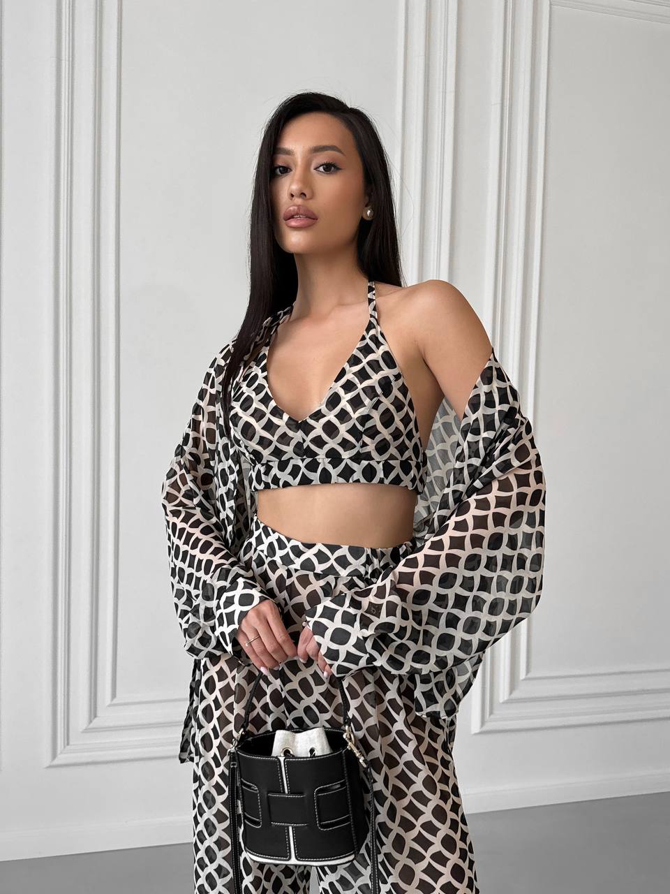 Woman wearing a leopard print outfit against a white wall