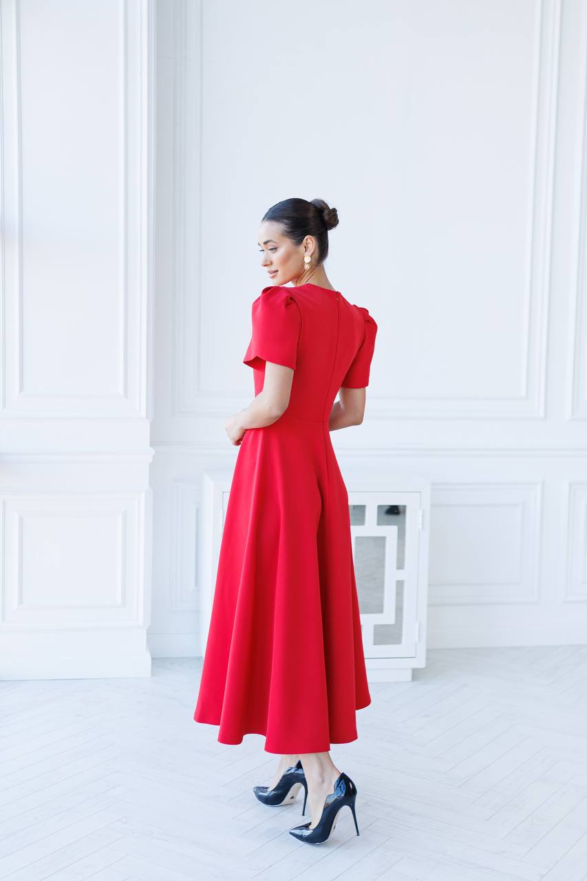 Woman wearing a red dress in a white room