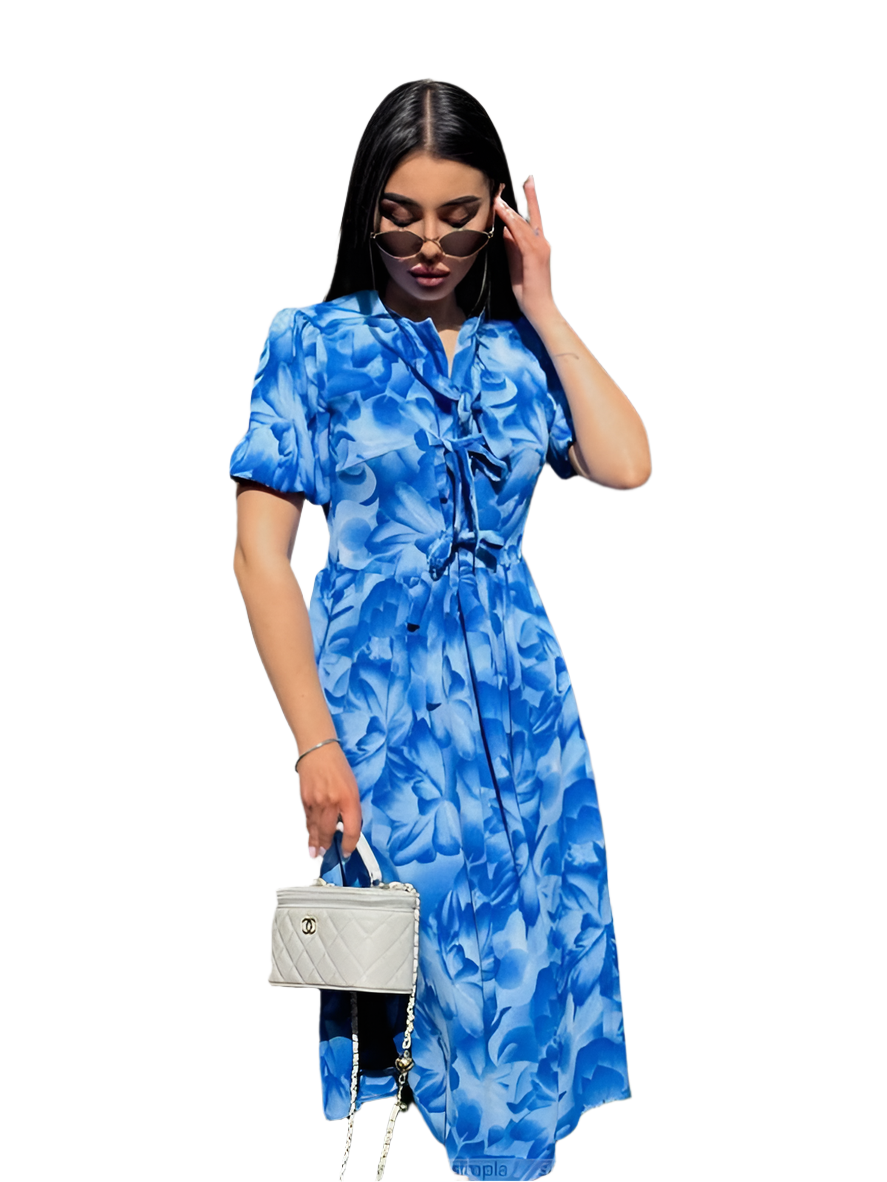 Woman wearing a blue floral dress holding a white handbag on a white background