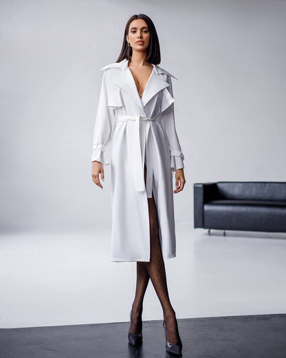 Woman wearing a white trench coat in a minimalistic setting