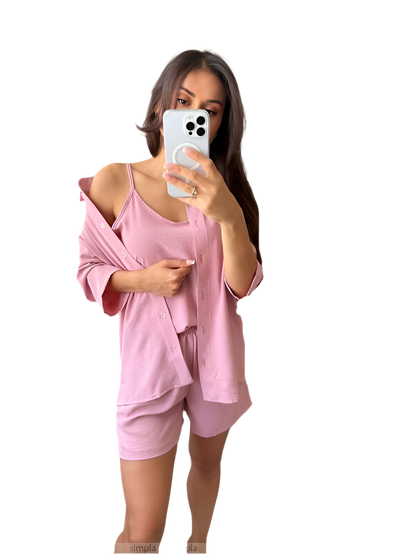 Woman taking a mirror selfie wearing a pink outfit on a white background