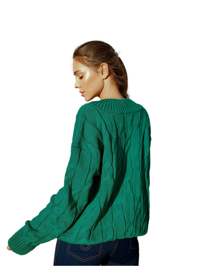 Person wearing a green cable knit sweater on a white background