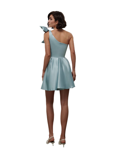 Woman wearing a light blue one-shoulder dress on a white background