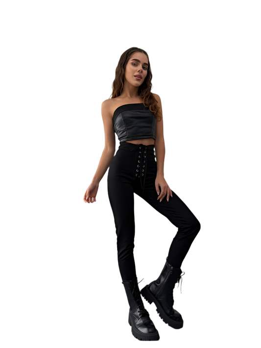 Woman wearing a black outfit with a strapless top and high-waisted pants on a white background