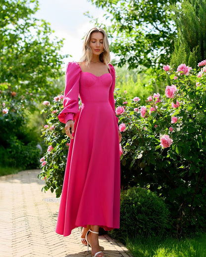 Woman in a pink dress standing in a garden with pink flowers