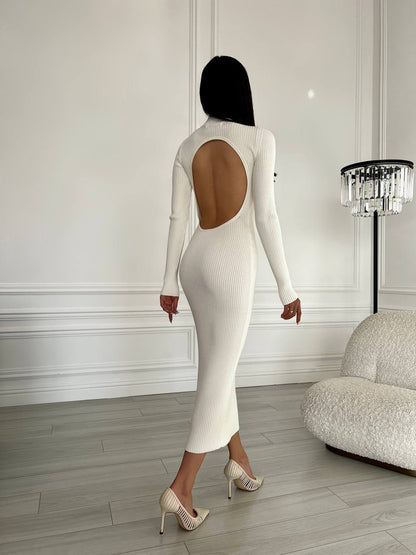 Person wearing a white dress with a cutout back in an elegant room.