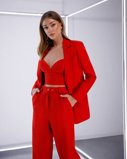 Woman wearing a red suit in a minimalistic setting