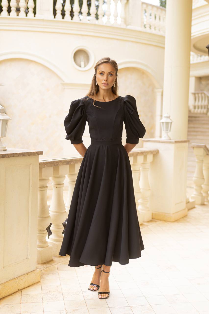 Woman wearing a black dress in an elegant interior setting