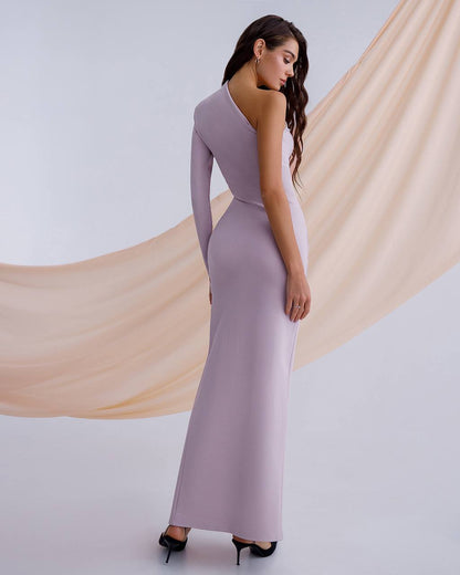 Woman wearing a long, light purple dress with a flowing fabric backdrop.