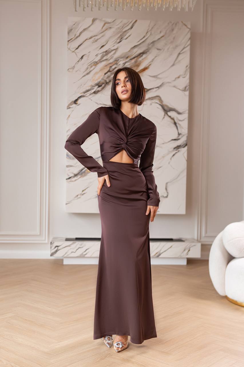 Woman in a brown outfit standing in a stylish room with marble wall art.