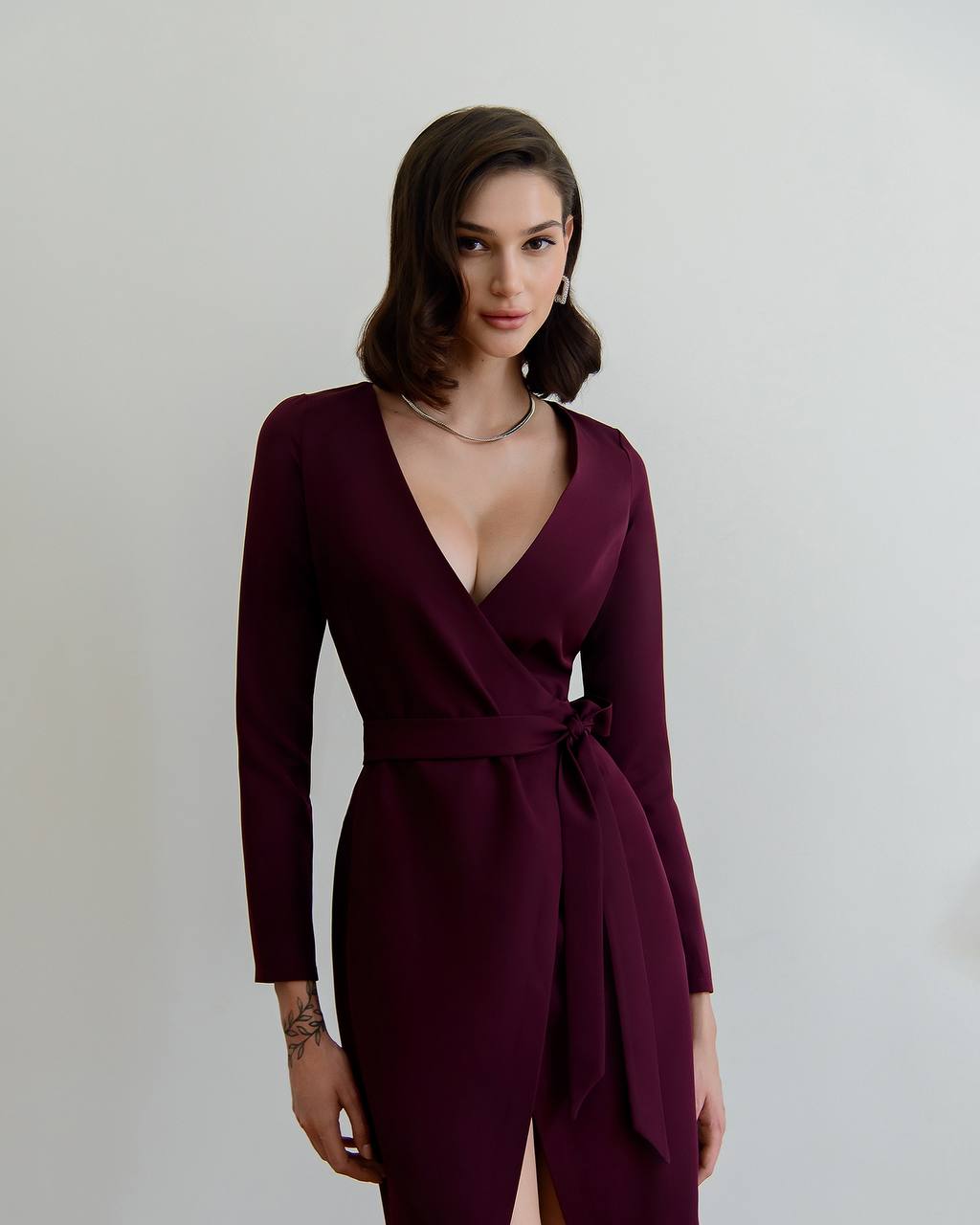 Woman wearing a burgundy dress against a plain background