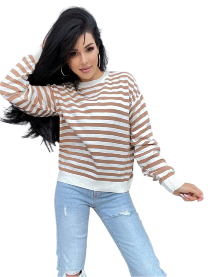 Woman wearing a brown and white striped sweater and light blue jeans on a white background