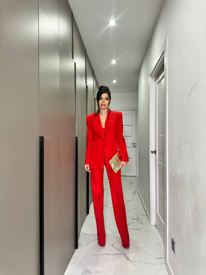 Person in a red suit standing in a modern hallway.