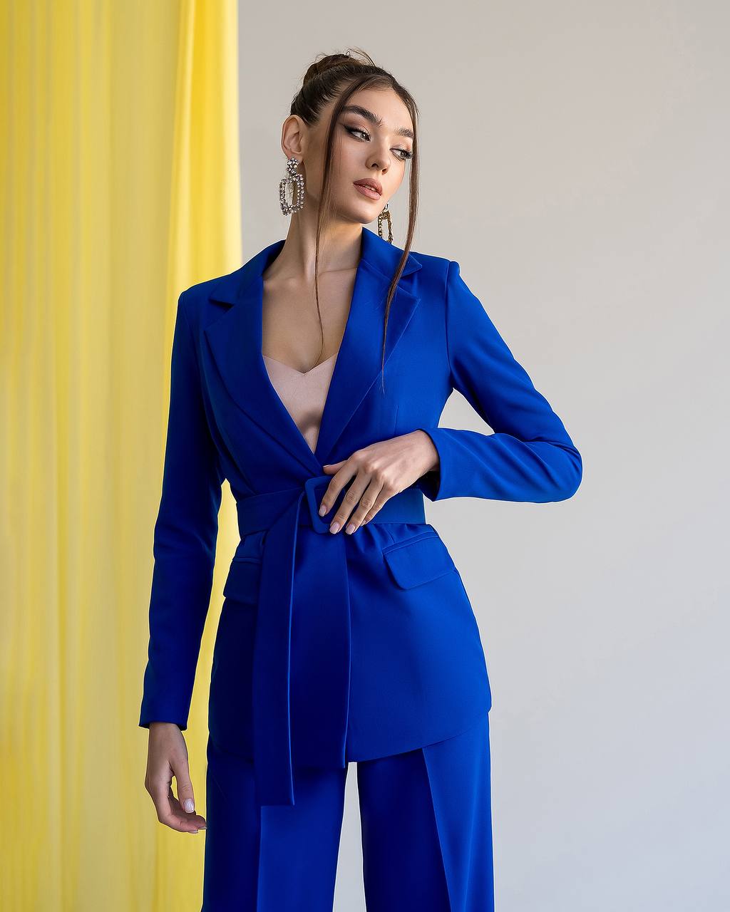 Woman wearing a blue suit with a yellow and white background