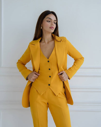 Woman wearing a mustard yellow suit against a white background
