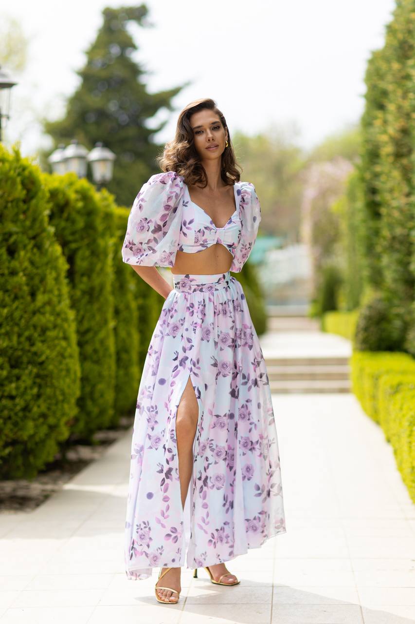 Woman wearing a floral dress with a high slit in a garden setting