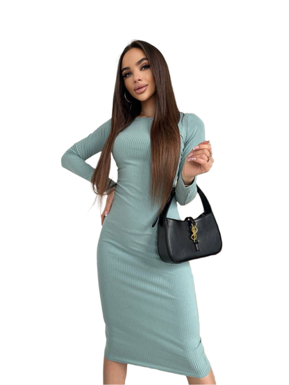 Woman wearing a light blue ribbed dress holding a black handbag on a white background