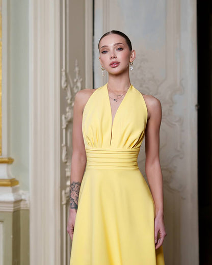Woman wearing a yellow dress in an elegant interior setting