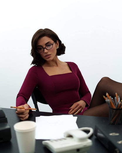 Woman sitting at a desk with office supplies and a white background