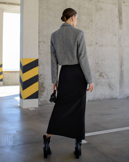 Person wearing a checkered shirt and black skirt in an industrial setting